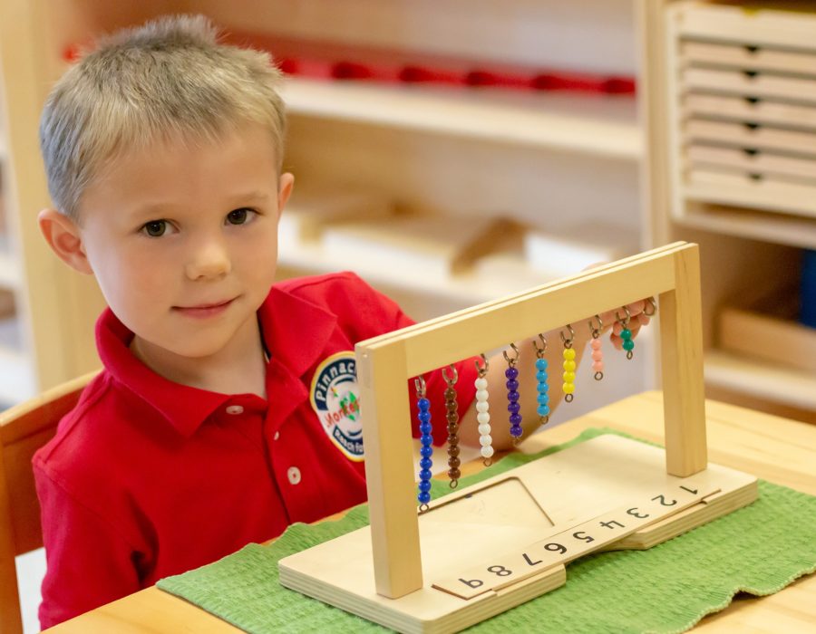 A young child at Pinnacle Montessori of Castle Hills plays with beads.