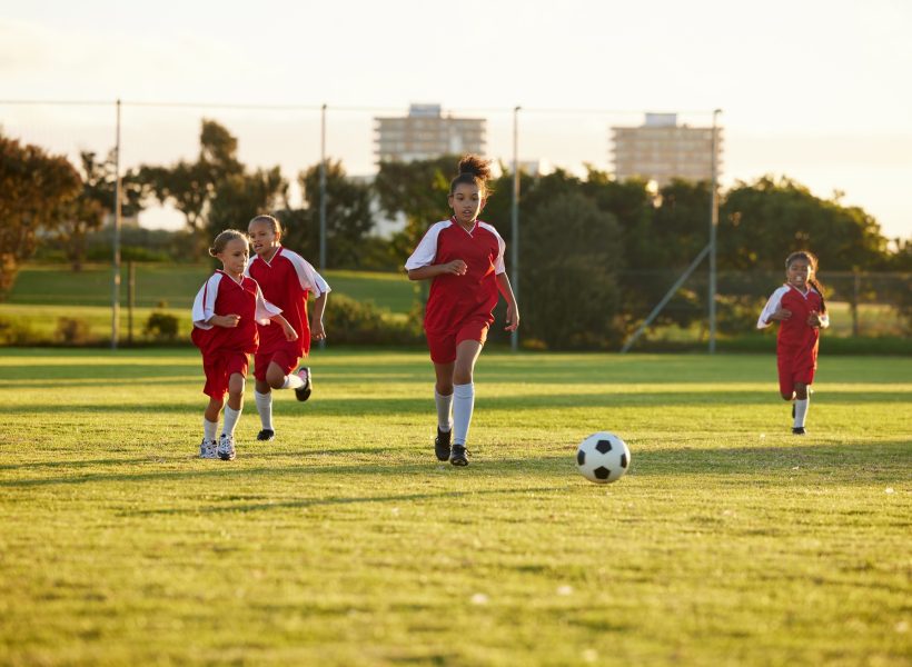 Sports, fitness and soccer training by girl team playing on grass field, teamwork during football g