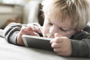A kid is focused on using the tablet.