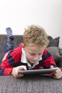 A kid is playing with the tablet.