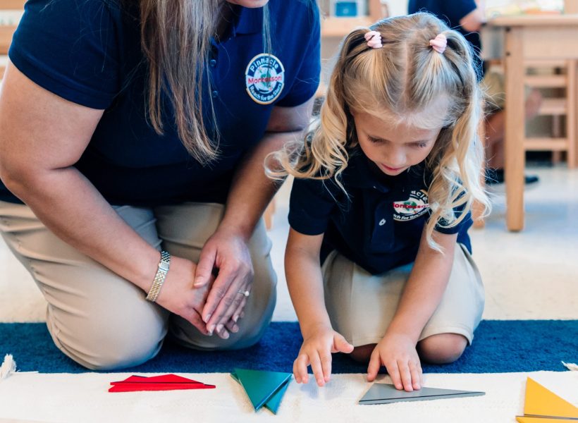 A teacher is guiding a student in creating paper crafts at Pinnacle Montessori of Alliance.