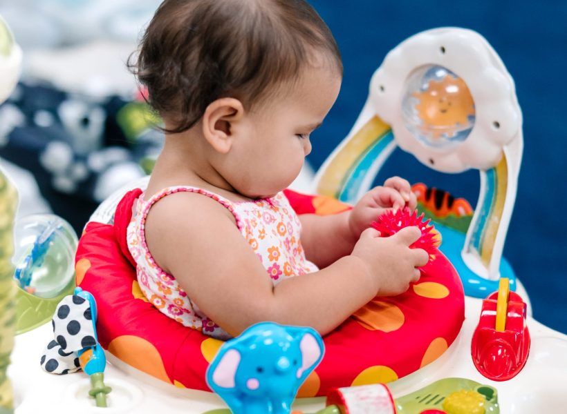 An infant is using a walker to explore at Pinnacle Montessori of Alliance.
