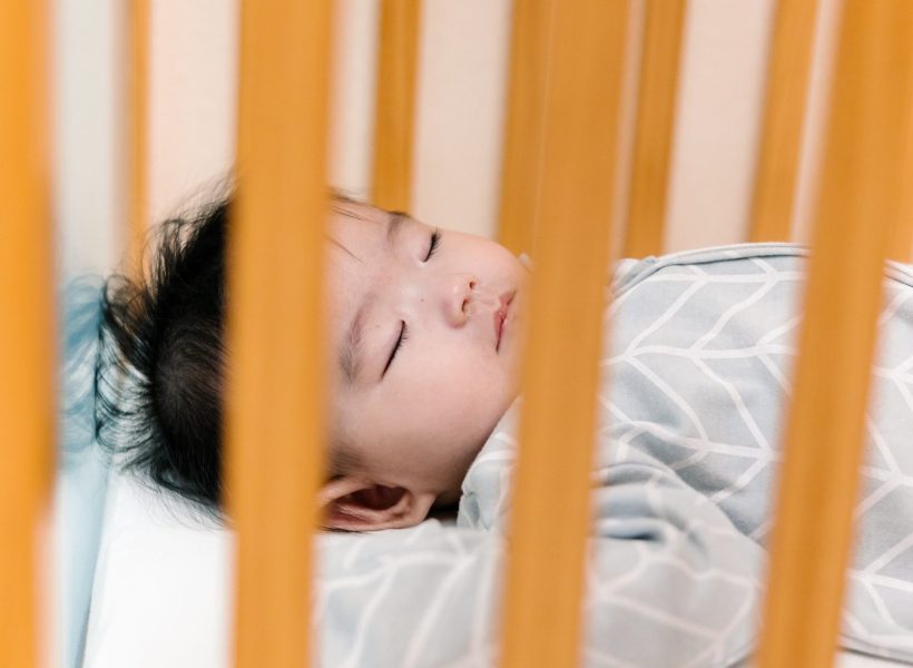 An infant is peacefully sleeping at Pinnacle Montessori of Alliance.