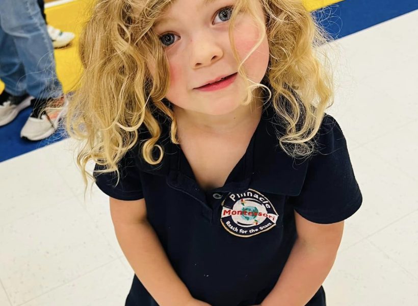 A happy Child participating in a collaborative learning activity at Pinnacle Montessori of Forney,