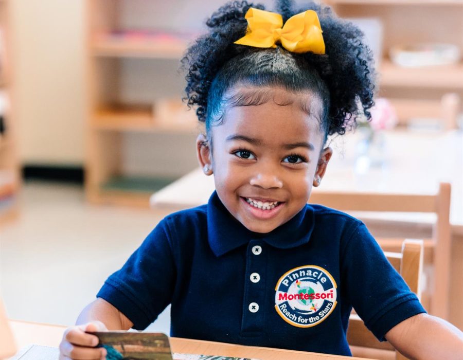 A North American student deeply engaged in a hands-on Montessori activity at Pinnacle Montessori of Forney,
