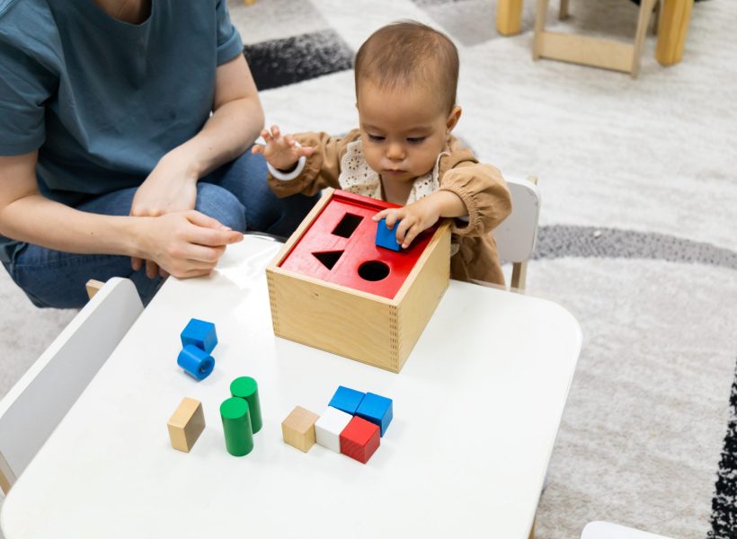 A toddler playing with a Montessori imbucare shapes box at Pinnacle Montessori of Forney,