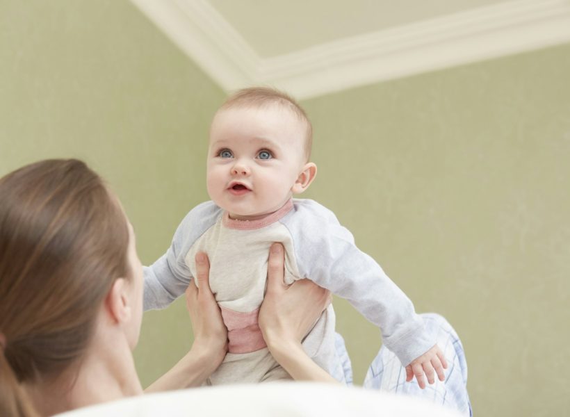 A heartwarming moment of a mother holding her baby daughter, reflecting the family-oriented values and nurturing atmosphere at Pinnacle Montessori of Forney
