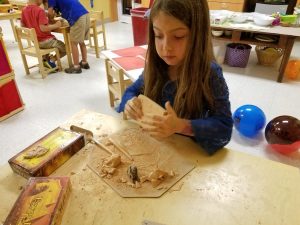 A cute girl is busy making sculptures at Pinnacle Montessori of Schertz.
